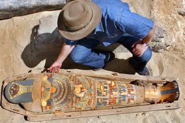 Zahi Hawass, chief of Egypt's Supreme Council of Antiquities, checks a brilliantly colored mummy dating back more than 2,300 years