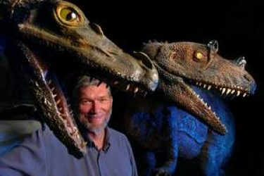 Ken Ham poses with dinosaur models in his unfinished $25 million Answers in Genesis museum.