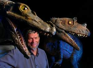 Ken Ham poses with dinosaur models in his unfinished $25 million Answers in Genesis museum.